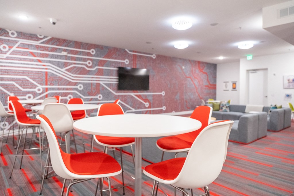 a room with a table and chairs and a wall with a television at 20 Midtown, Alabama, 35233